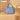 Blue handbag with Wrangler logo on a beige background